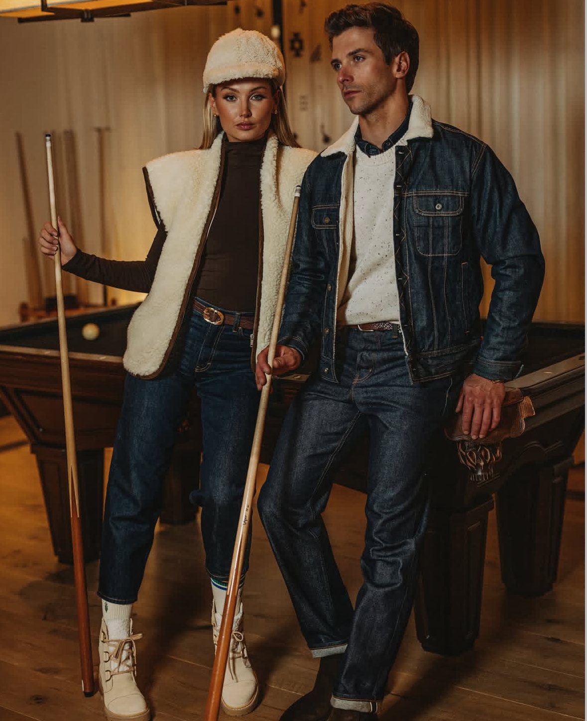 At a pool table with a male model, both in shearling and denim, holding pool cues
